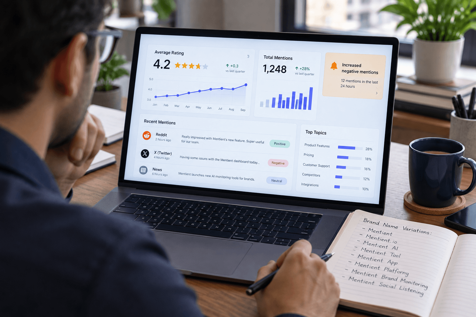 A marketing lead at a desk reviewing a reputation dashboard with a star rating trend, a mentions feed, and an alert badge, notebook open beside the keyboard